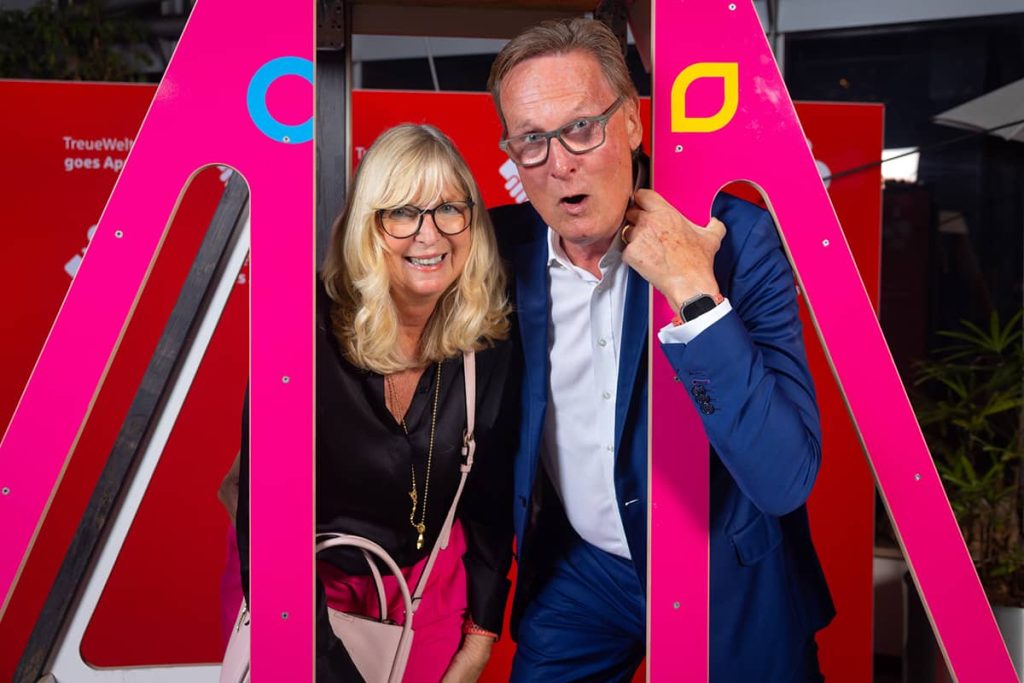 Eine blonde Frau und ein Mann mit Brille posieren gut gelaunt in der Gondel